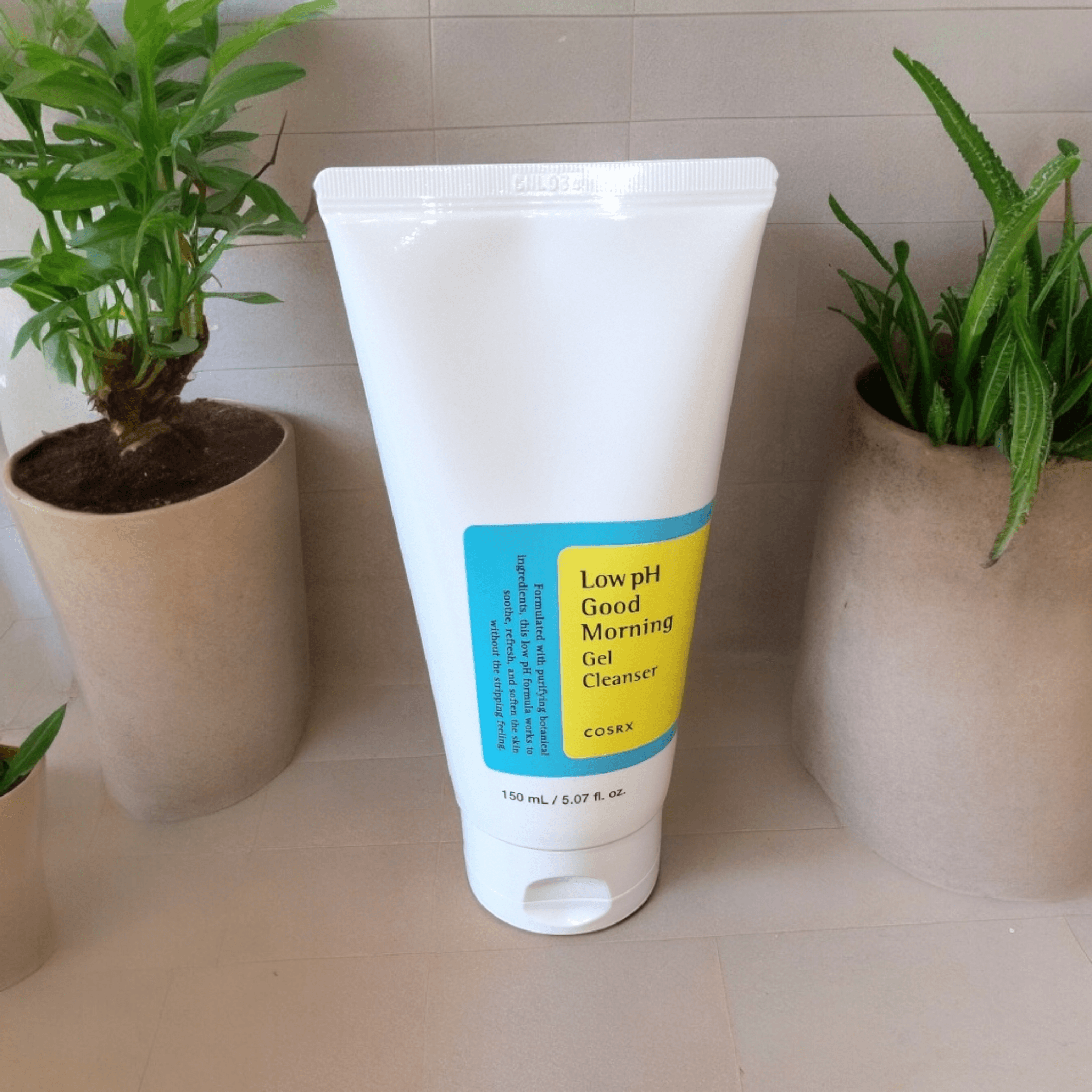 COSRX - Low pH Good Morning Gel Cleanser front view in bathroom with tiles and a couple of plants